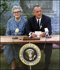 President Johnson at 1965 signing, with his childhood teacher Kate Deadrich Loney.